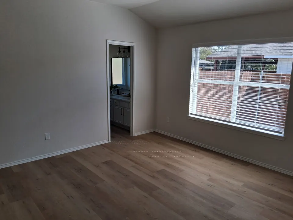 Empty bedroom with clean vinyl plank floor after a move-out cleaning