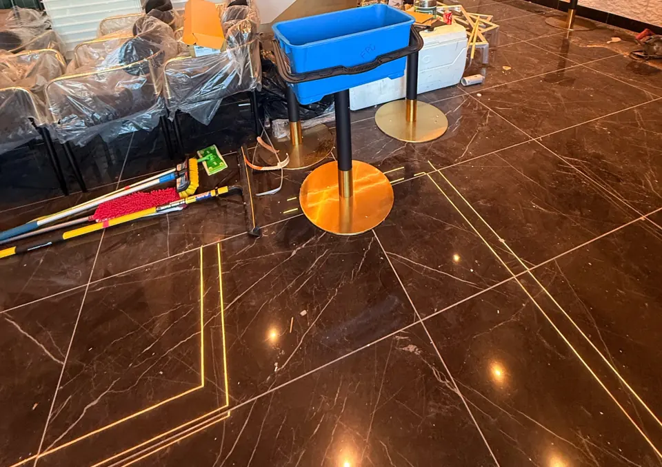 DURING: commercial dining room under construction with cleaning bucket and mops, during cleanup