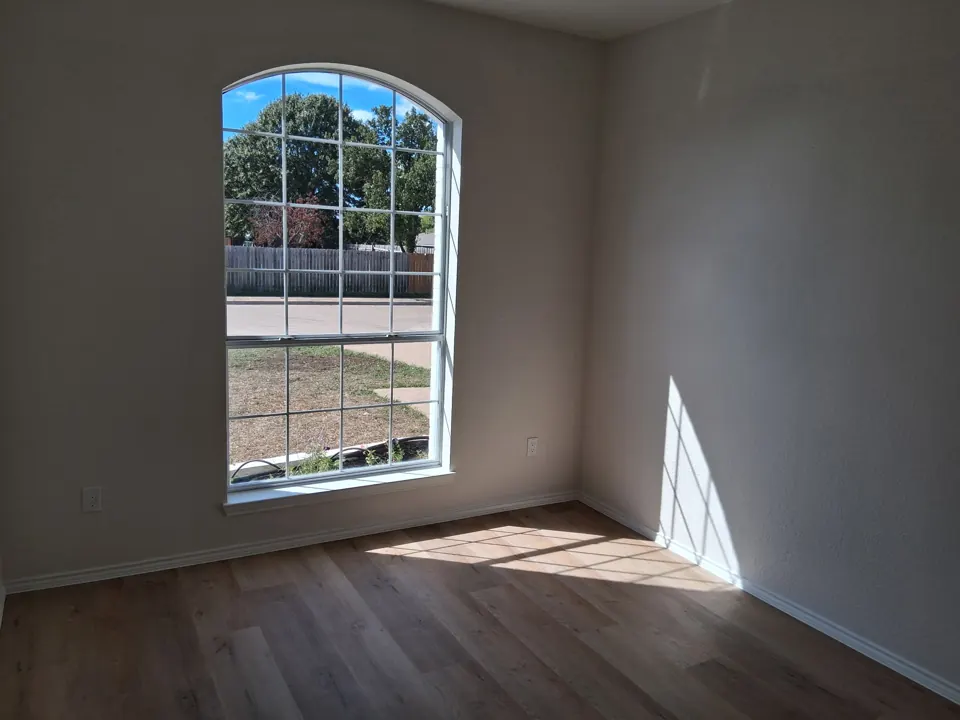Sunny, freshly cleaned empty room with arched window