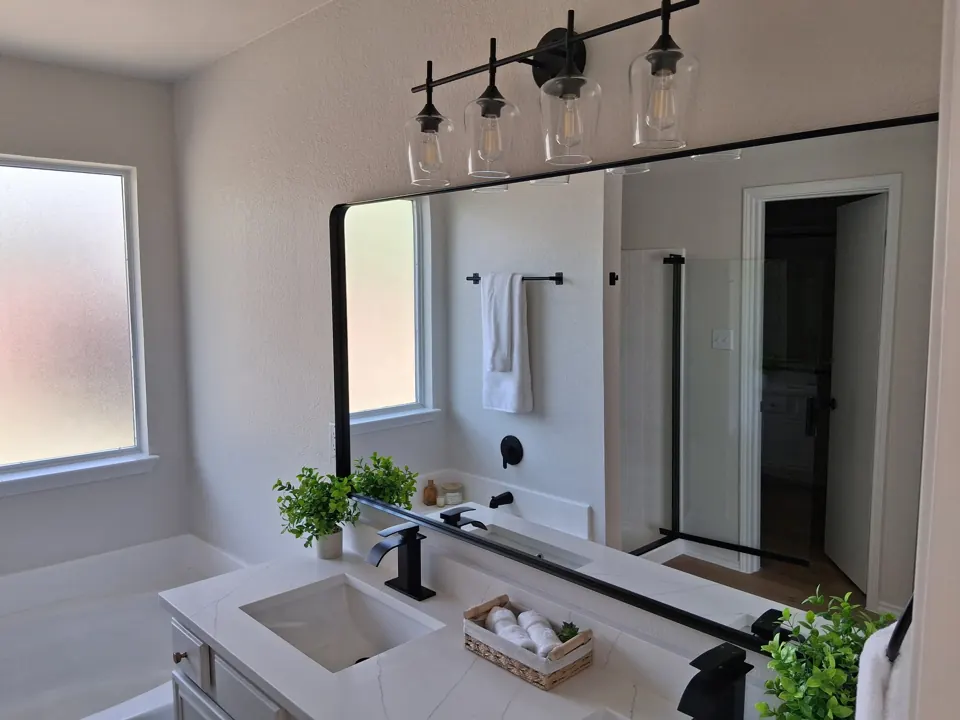 Freshly cleaned bathroom vanity with black fixtures after a Famous Pink Cleaning make-ready clean